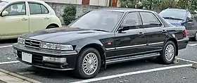 Front three-quarter view of a four-door car with a three-box body style.